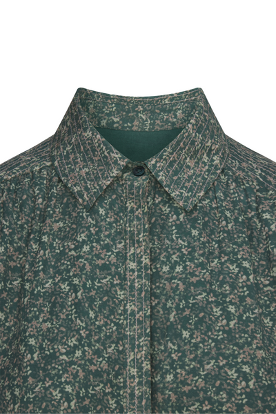 Green patterned shirt with collar and button on a white background