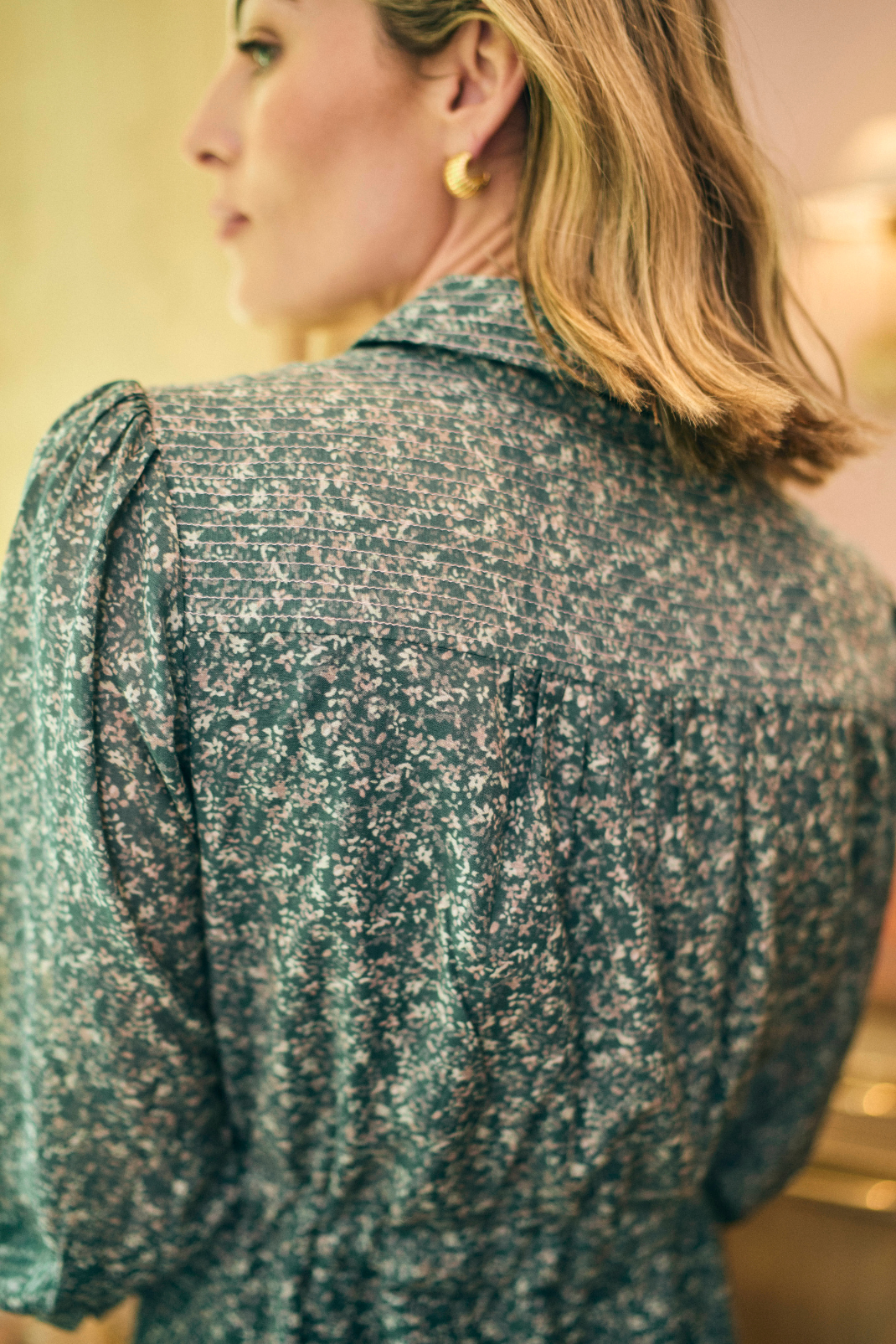 Woman wearing a patterned shirt with a blurred background