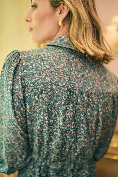 Woman wearing a patterned shirt with a blurred background