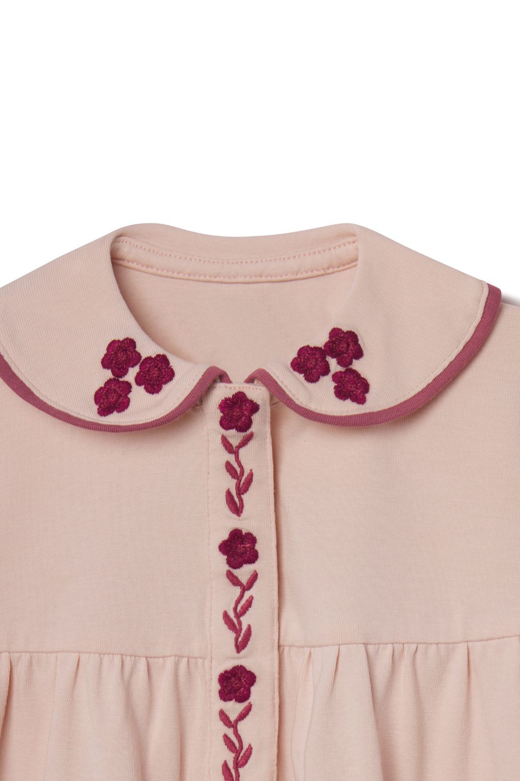 Pink dress with floral embroidery on a white background