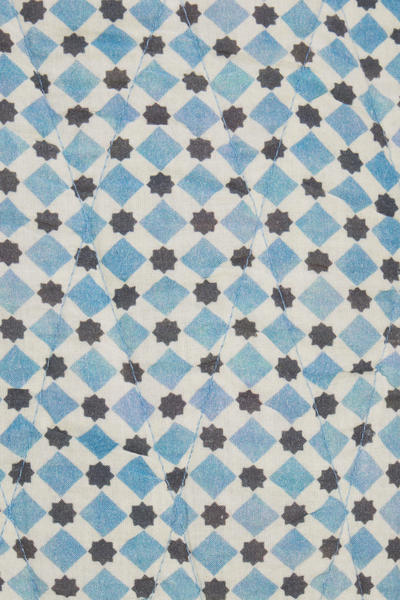Patterned fabric with blue and black diamond shapes on a white background