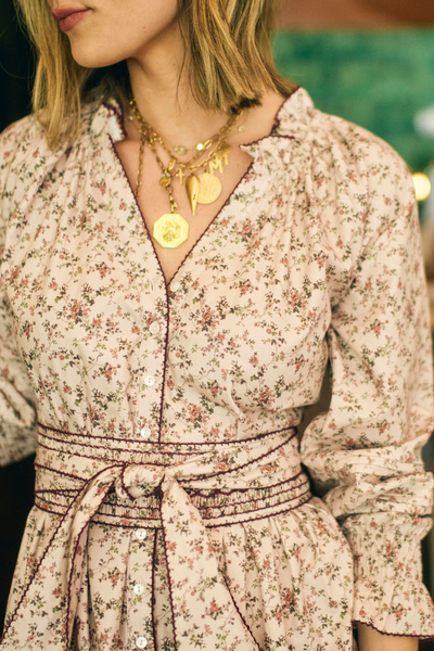 Woman wearing a floral dress with a close-up of her neck and upper chest.