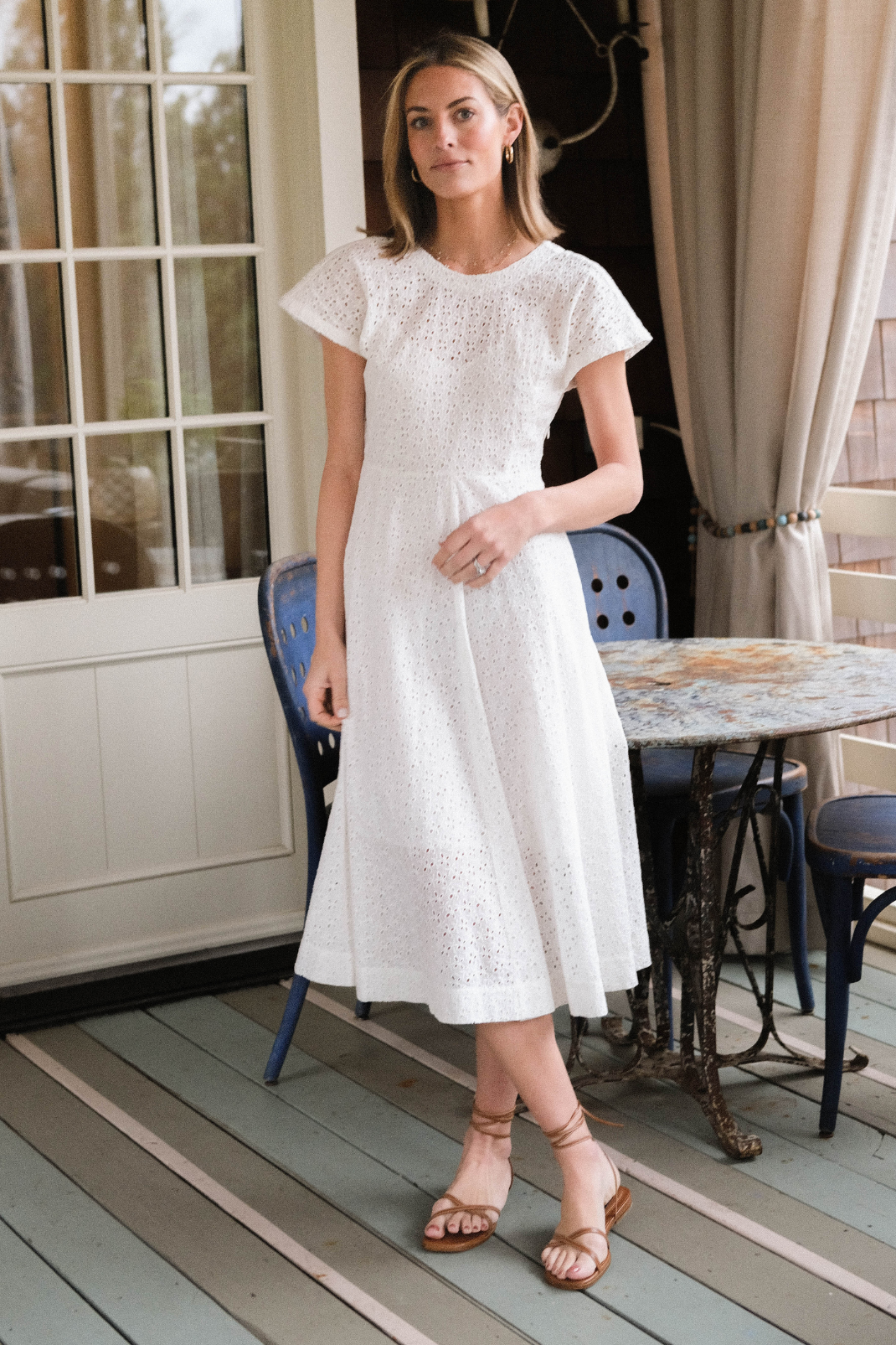 Woman standing in white eyelet dress