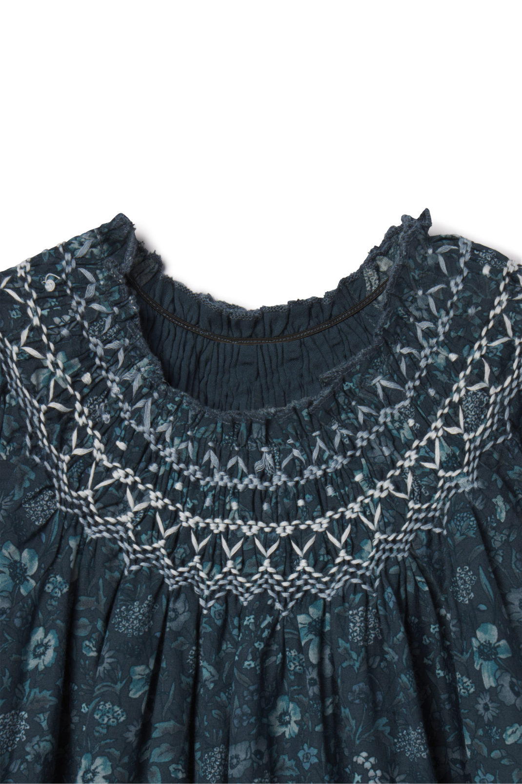 Close-up of a dark blue patterned dress with intricate lace detailing on a white background