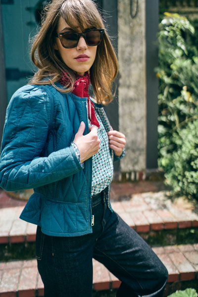 Woman wearing a blue jacket and sunglasses outdoors