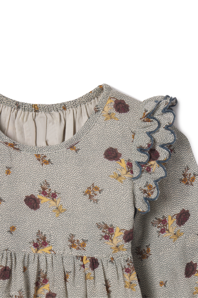 Floral patterned dress with ruffled details on a white background