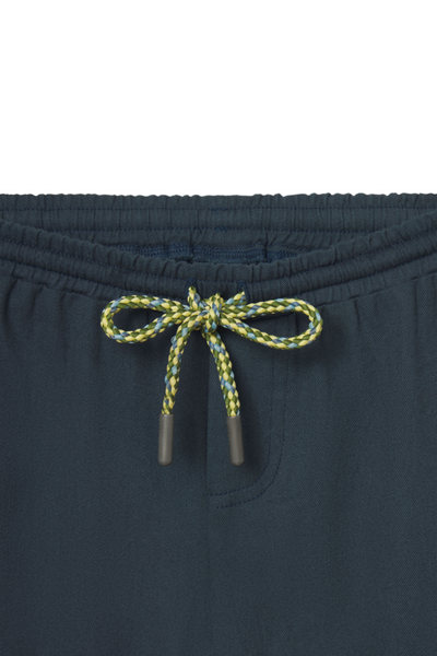 Navy pants with a green and yellow drawstring on a white background