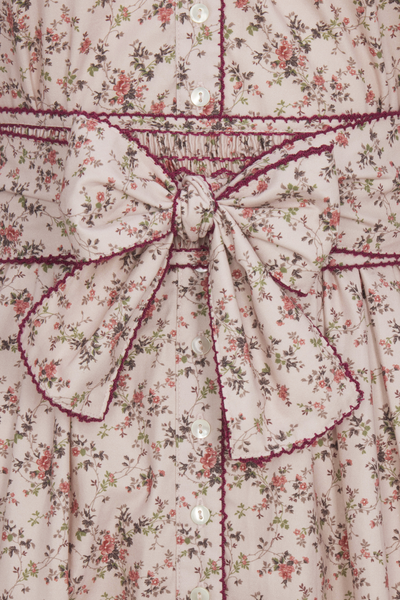 Floral dress with a large bow detail on a patterned background