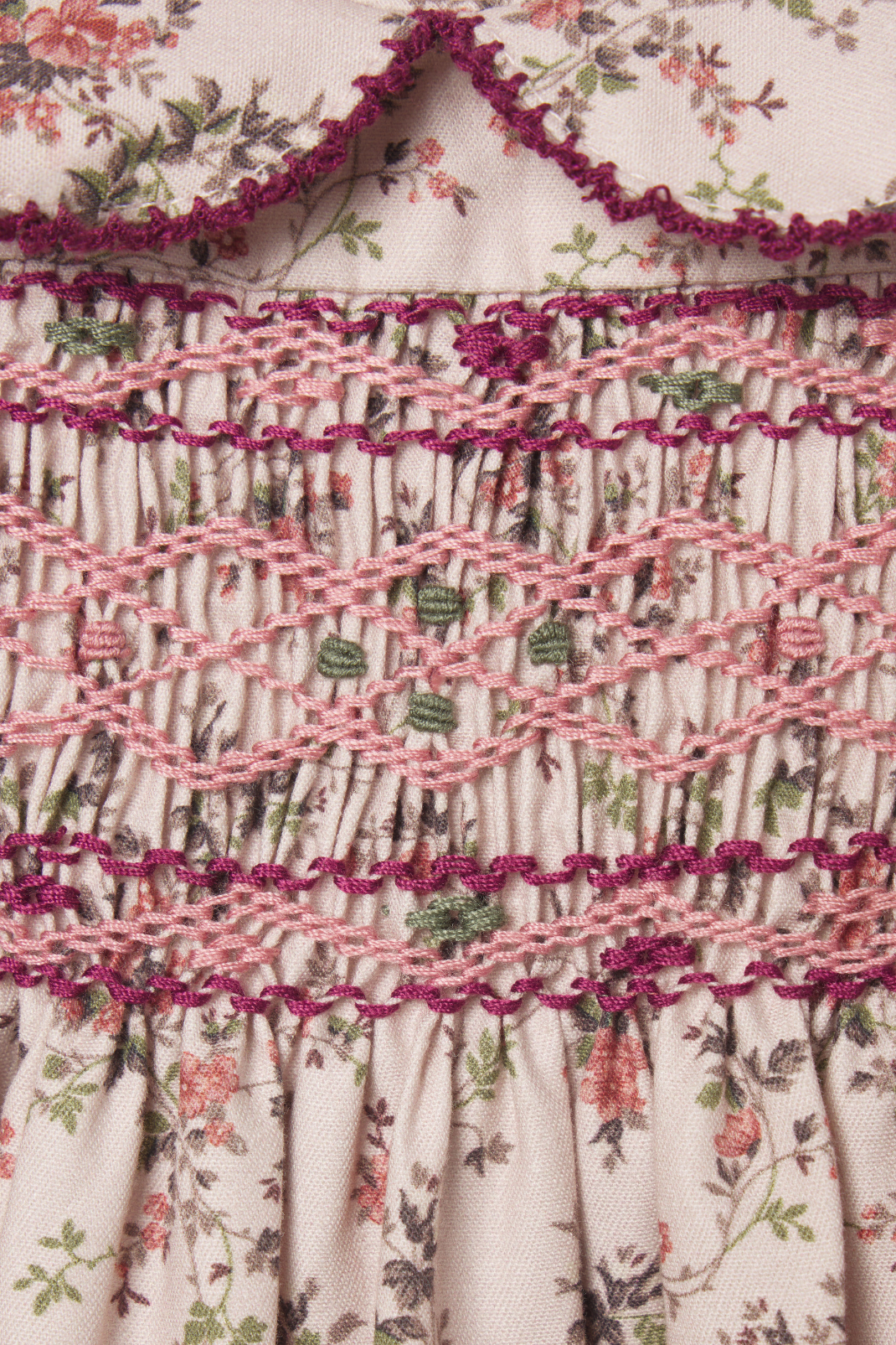 Close-up of a floral dress with smocked waist and ruffled trim.