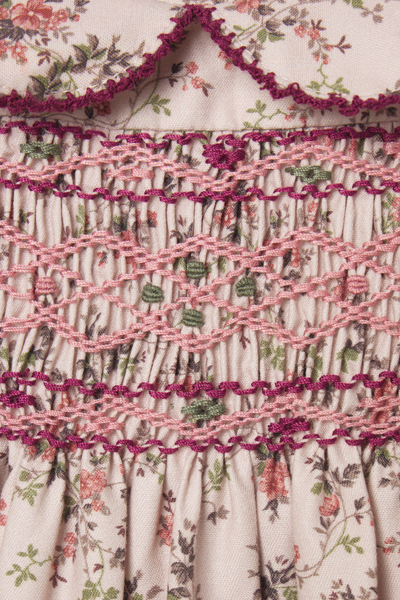 Close-up of a floral dress with smocked waist and ruffled trim.