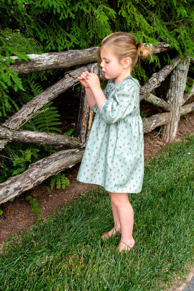 Little girl wearing the Ashley Dress in Tiny Tulip playing outside