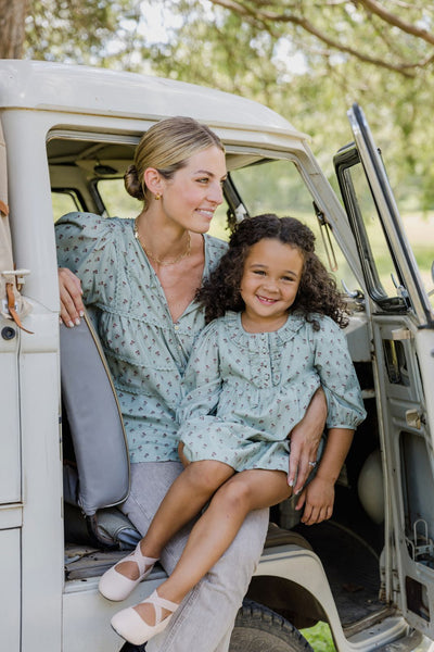 Lifestyle image of a mother and daughter sitting in a truck wearing pieces in the tiny tulip print