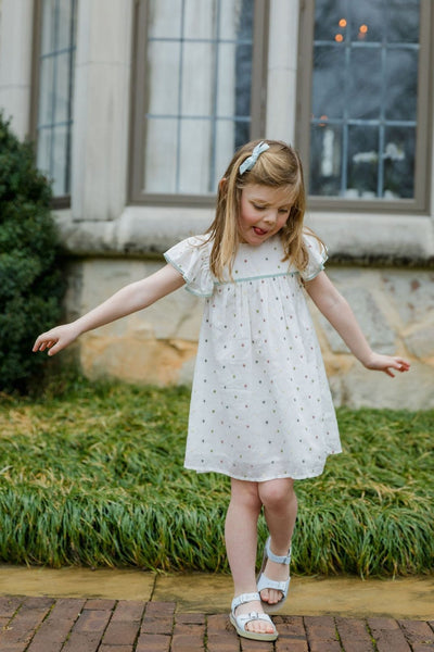 Lifestyle shot of a little girl outside wearing the Dolly Dress