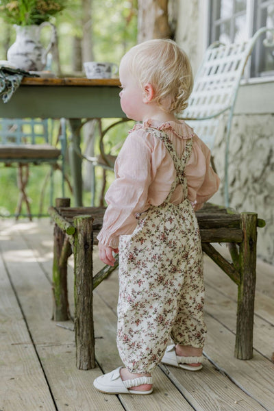 Back shot of a little girl wearing the Shaw Playsuit in Overgrown floral