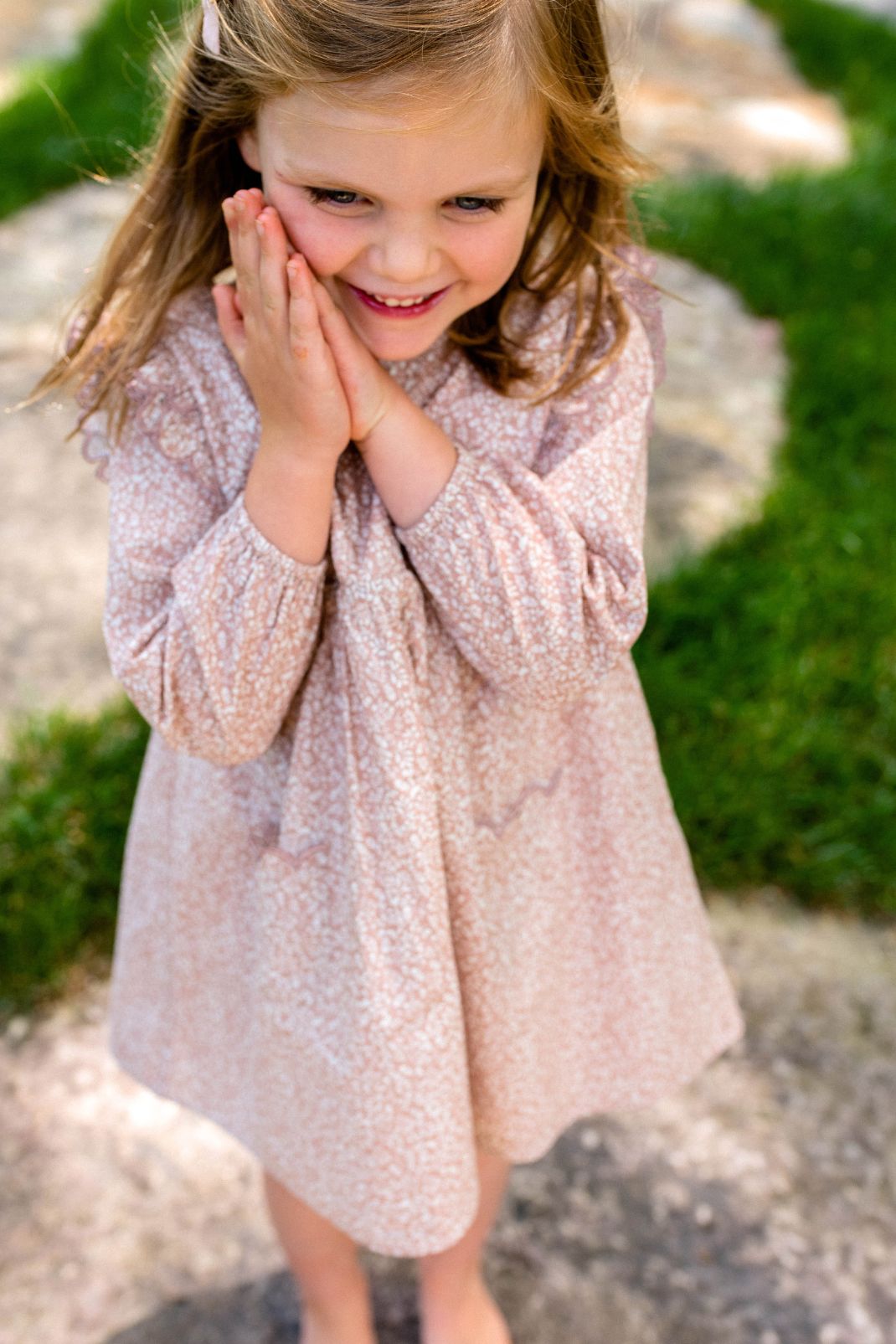 Lifestyle shot of a little girl in the Kate Dress in Rose Dawn