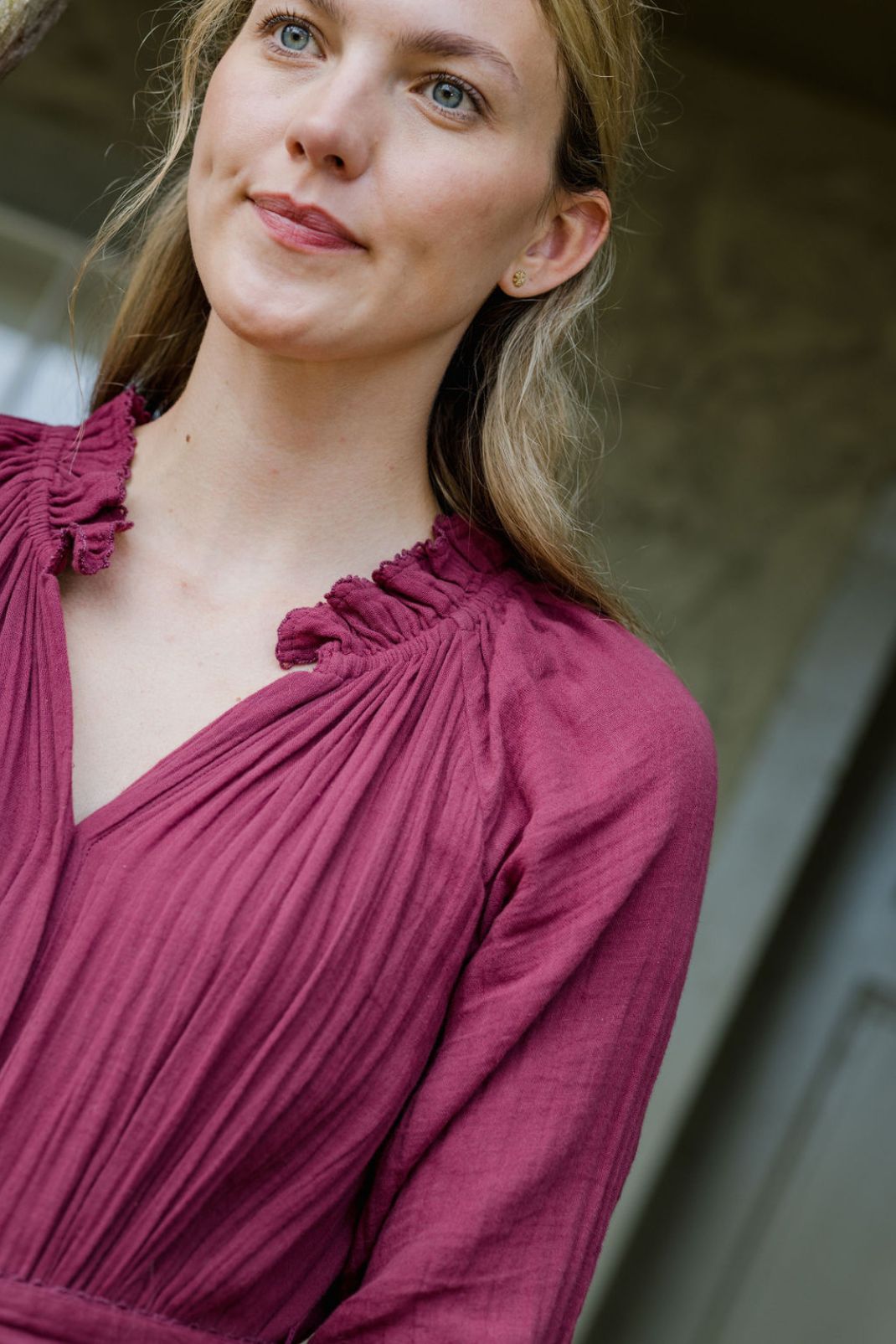 Close up lifestyle shot of a woman wearing the Vivianne Dress in Cranberry