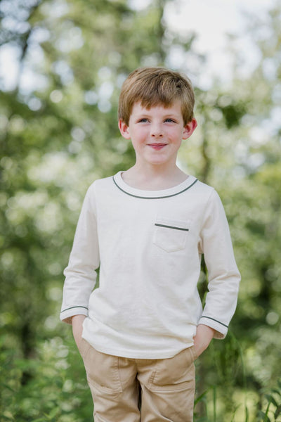Lifestyle shot of a little boy outside wearing the Joey T-Shirt in Ivory with Thyme