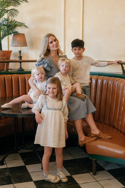 Shot of a mother wearing the Lilibet Dress in Faded Denim surrounded by her children