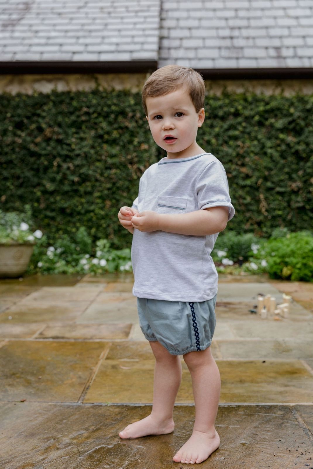 Lifestyle shot of little boy outside wearing a tee shirt and shorts
