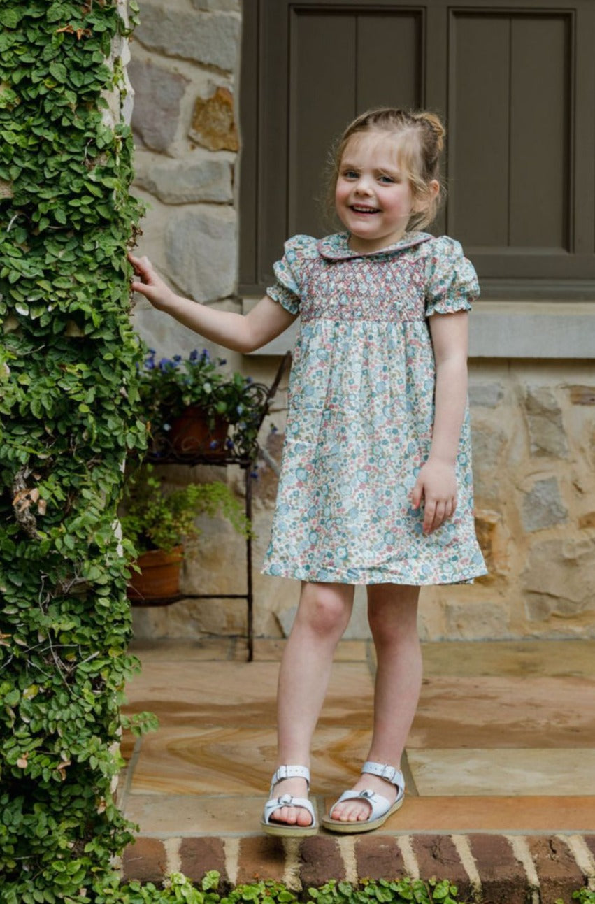 Little girl standing outside wearing the Emmy Dress in Floral Breeze