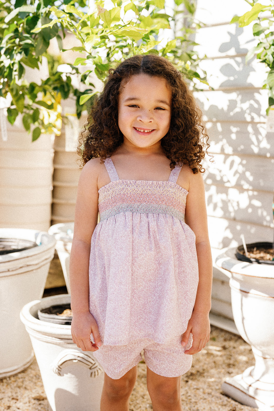 Lifestyle shot of a little girl wearing the Rosie Girls Set in Scattered Blooms